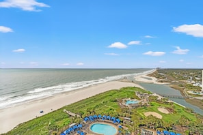 A resort with a swimming pool, beach access, and a view of the ocean.