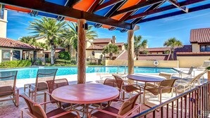 A poolside area with outdoor seating and a view of a pool. - Oceanfront 2 Bedroom/2 Bath Windsong (Fernandina Beach)