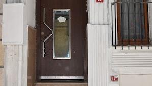 A brown door with a small window, flanked by white columns and a metal gate. - Taksim Palace Hotel Apart  (Istanbul)