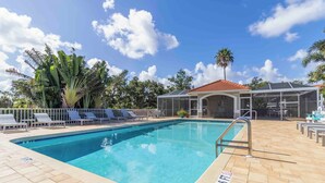 A swimming pool with lounge chairs and a covered area. - Amazing 2 bedroom unit located on golf course near Siesta Key Beaches (Sarasota)