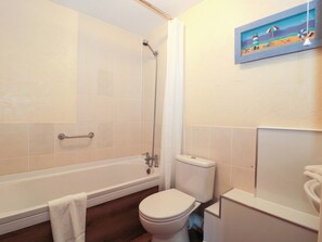 A bathroom with a bathtub, toilet, and a shower. - Owls Retreat (Weston-super-Mare)