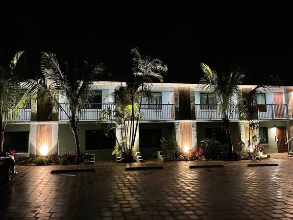 Un hotel con patio, palmeras y una cascada.