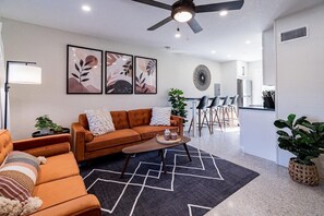 A modern living room with a sofa, coffee table, and artwork on the wall.