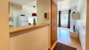 Et moderne køkken med hvide hårde hvidevarer, en træbordplade og en rød hængende lampe.