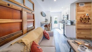 Een moderne keuken met witte kasten, een houten aanrecht en een inbouwoven.