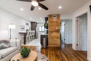 Un salon moderne avec un canapé, une table basse et un ventilateur de plafond.