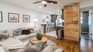 A modern living room with a sofa, coffee table, and a ceiling fan. - 400 South - Unit F (Cocoa Beach)