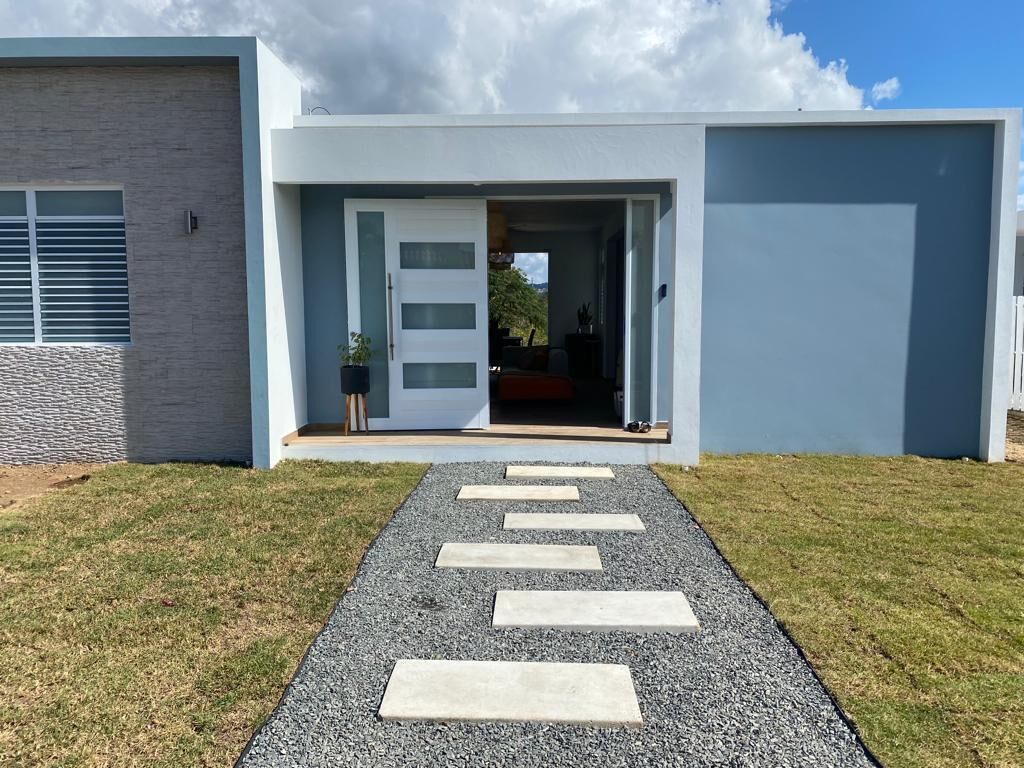 Ett modernt hus med en grusgång som leder fram till en dörr.