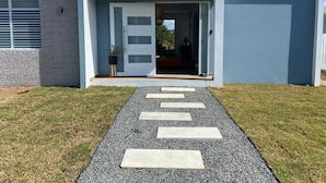 Ein modernes Haus mit einem Kiesweg, der zu einer Tür führt.