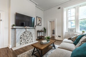 A living room with a fireplace, a flat-screen TV, a sofa, and a coffee table. - 🏰Warren Castle🏰 - Breathtaking Views of Pittsburgh 💙 (Pittsburgh)