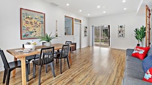 A dining area with a wooden table and chairs, a large map on the wall, and a grey sofa with red cushions. - The Red Lodge - Unique Gem Near Lakes with Game Room and Hot Tub! (Elkhorn)