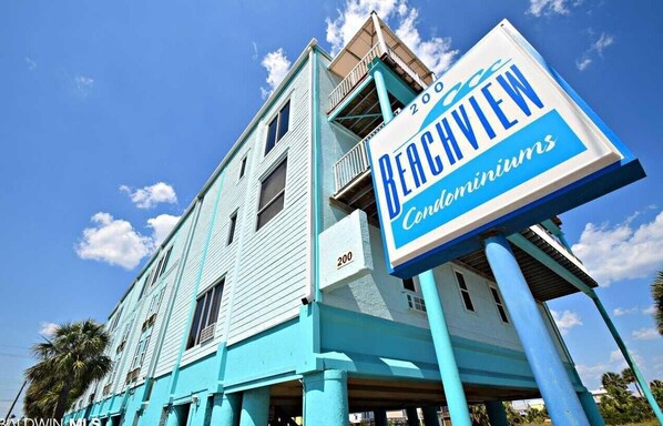 A turquoise building with a sign for Beachview Condominiums.