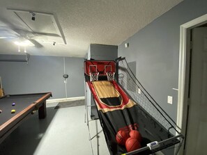 Une pièce équipée d’une table de billard, d’un panier de basket et d’un terrain de futsal.