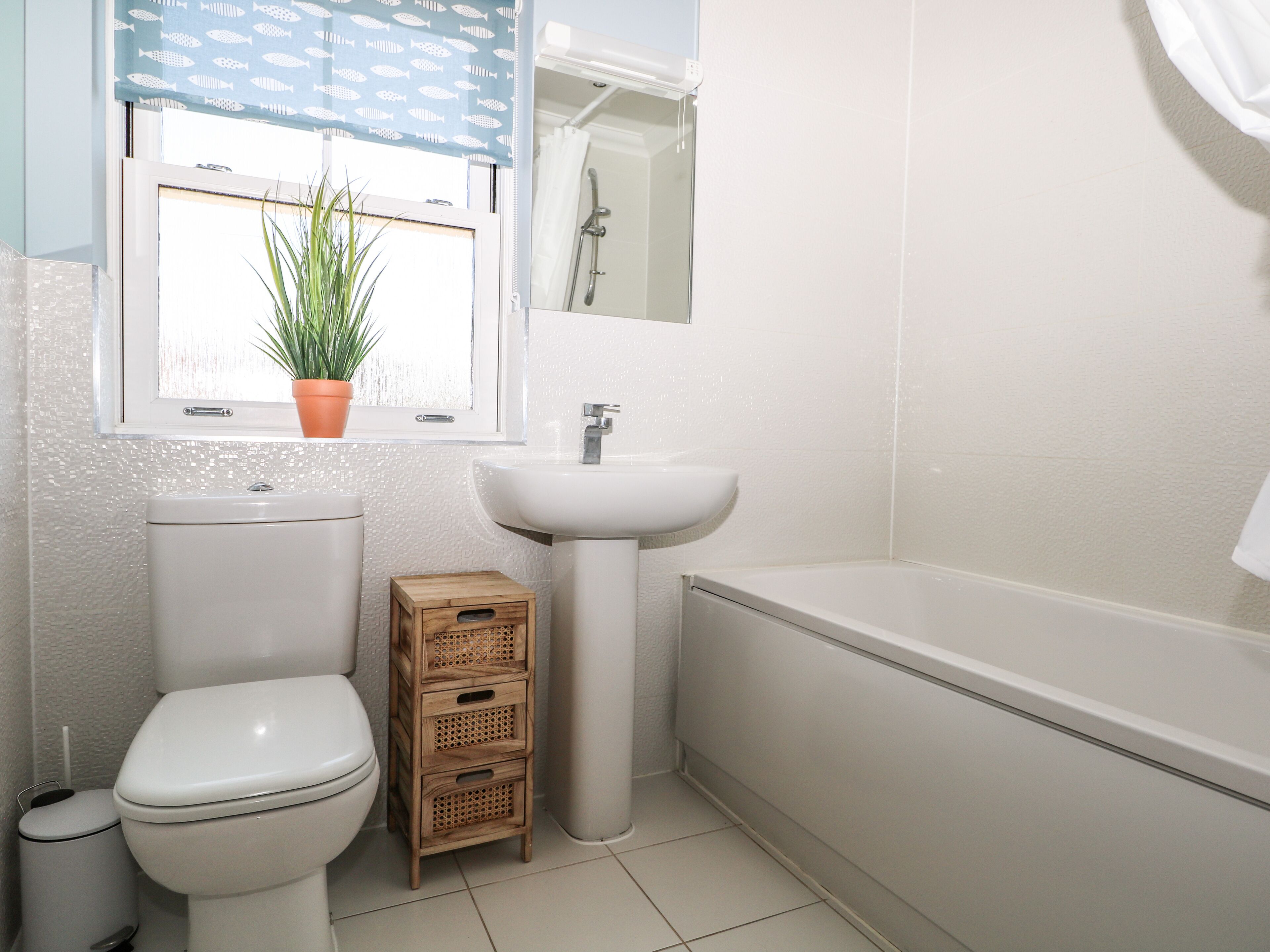A bathroom with a toilet, sink, and bathtub.