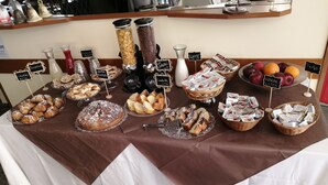 A buffet table with various food items and condiments, including pastries, fruits, and cheese. - Hotel Luca (Rimini)