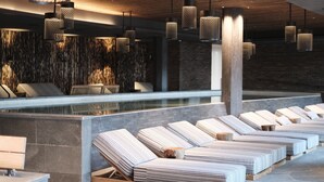 A modern spa area with a pool, lounge chairs, and hanging pendant lights. - Ad Astra by Elite - Hotel, Spa & Resort (Sodertalje)