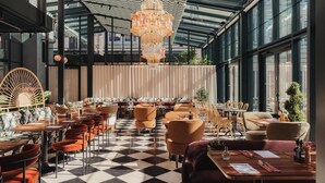 A restaurant with a checkered floor, multiple seating areas, and a large chandelier. - Ad Astra by Elite - Hotel, Spa & Resort (Sodertalje)