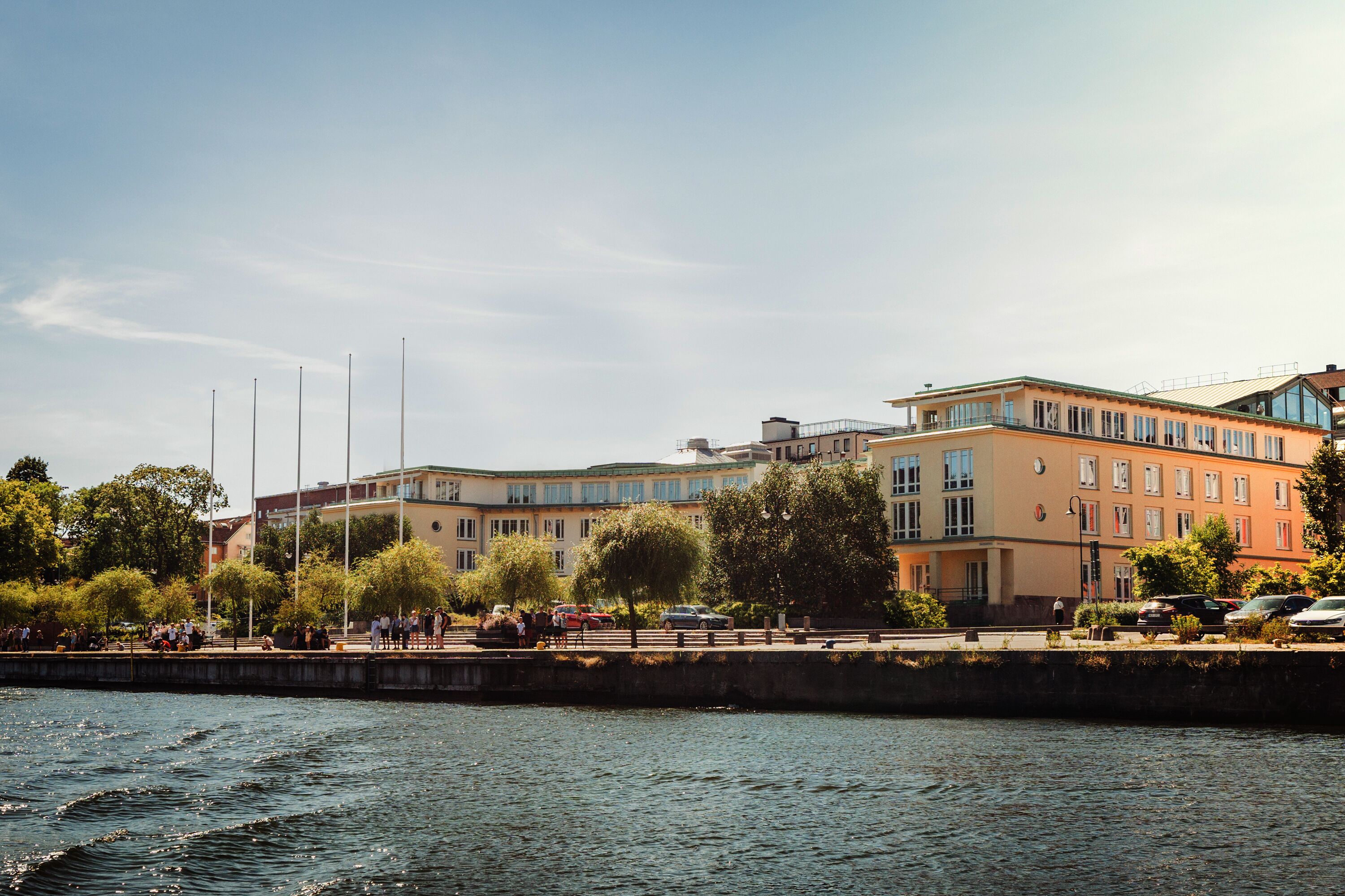 A waterfront building with multiple floors, large windows, and a flat roof.