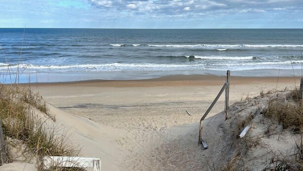 A beach with a sandy shore, waves, and a cloudy sky. - Ocean + sound views | Soooo close to the beach! (Duck)