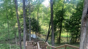 A wooden deck with a view of a river and forest.