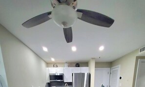 A kitchen with white cabinets, a microwave, and a refrigerator.