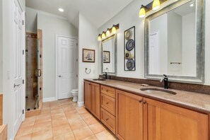 A modern bathroom with a large mirror, wooden cabinetry, and a glass shower enclosure. - 8 West Beach Lagoon at The Sea Pines Resort (Hilton Head Island)