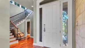 A staircase with wooden steps and a metal railing, leading to a door with a glass panel. - 8 West Beach Lagoon at The Sea Pines Resort (Hilton Head Island)