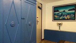 A room with a blue wardrobe, a door, a framed painting of a landscape, and a trophy on a stand. - La Casa di Paola - Four Bedroom Apartment, Sleeps 8 (Panoramica)