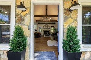 Une façade en pierre et un intérieur en bois, une cheminée et une horloge au mur.