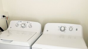 Two stacked front-loading washing machines in a room with wooden flooring. - Set within a beautifully restored 19th century home in the heart of Watkins Glen (Watkins Glen)