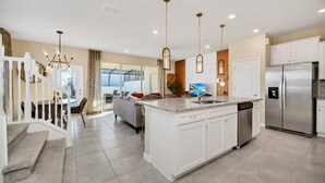 Una cocina moderna con una isla central, electrodomésticos de acero inoxidable y un comedor con vistas.