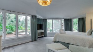 A spacious bedroom with a large bed, a seating area, and a television. - 9 Baynard Cove Road at The Sea Pines Resort (Hilton Head Island)