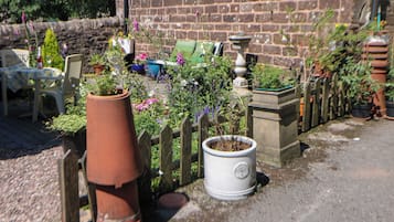 A garden with potted plants, a brick wall, and a wooden fence.
