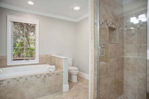 A bathroom with a bathtub, toilet, and glass shower enclosure. - 9 Green Heron at The Sea Pines Resort (Hilton Head Island)