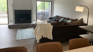 A living room with a fireplace, a sofa, a coffee table, and a lamp.