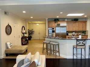 Enjoy cooking in this well-equipped kitchen with a refrigerator, oven, and island with bar stools.