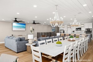 Una cocina moderna con armarios blancos, una isla grande e iluminación colgante.