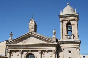 Eine Kirche mit einem Glockenturm, einer Kuppel und einem Kreuz auf dem Dach.