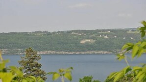 A view of a lake with a forested hillside in the background. - Gorgeous View Motel (Watkins Glen)