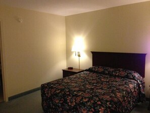 A hotel room with a bed, a nightstand, and a lamp. - Gorgeous View Motel (Watkins Glen)