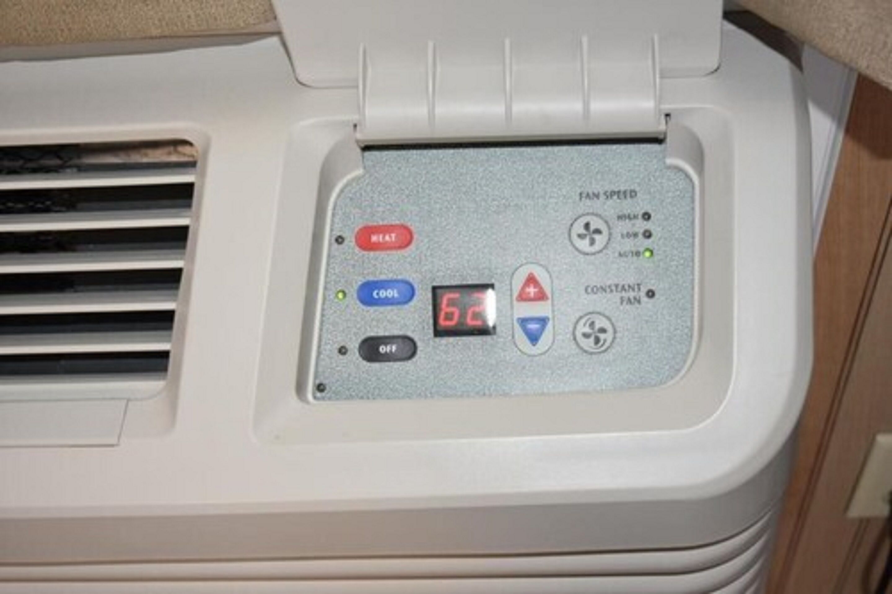 A control panel with buttons for heat, cool, and fan speed settings, and a digital display.