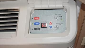 A control panel with buttons for heat, cool, and fan speed settings, and a digital display.
