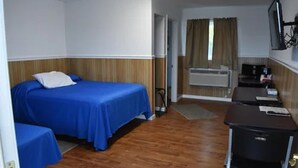 A hotel room with a bed, a desk, and a small kitchenette. - Gorgeous View Motel (Watkins Glen)