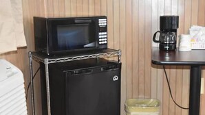A compact kitchen setup with a microwave, coffee maker, and a trash bin. - Gorgeous View Motel (Watkins Glen)