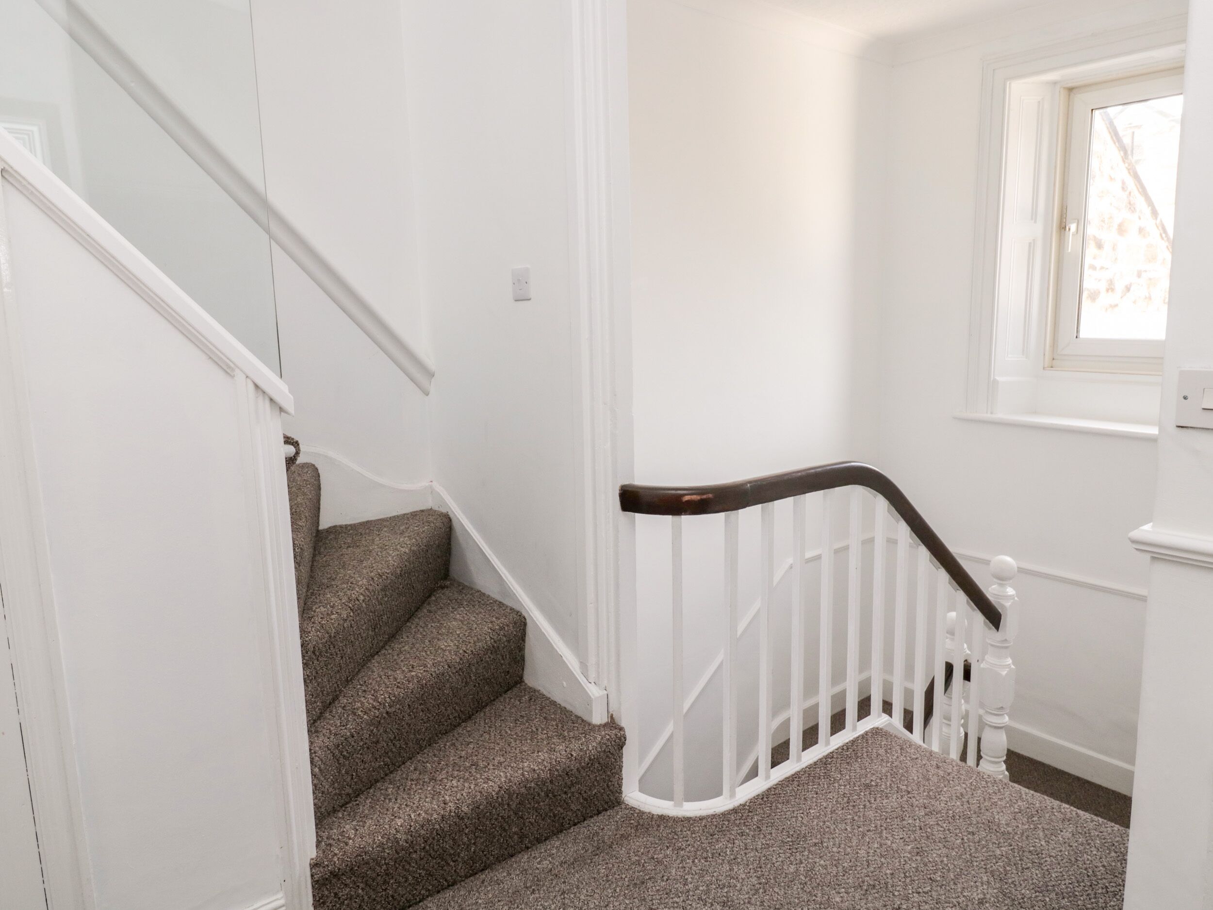 A staircase with carpeted steps and white railings.