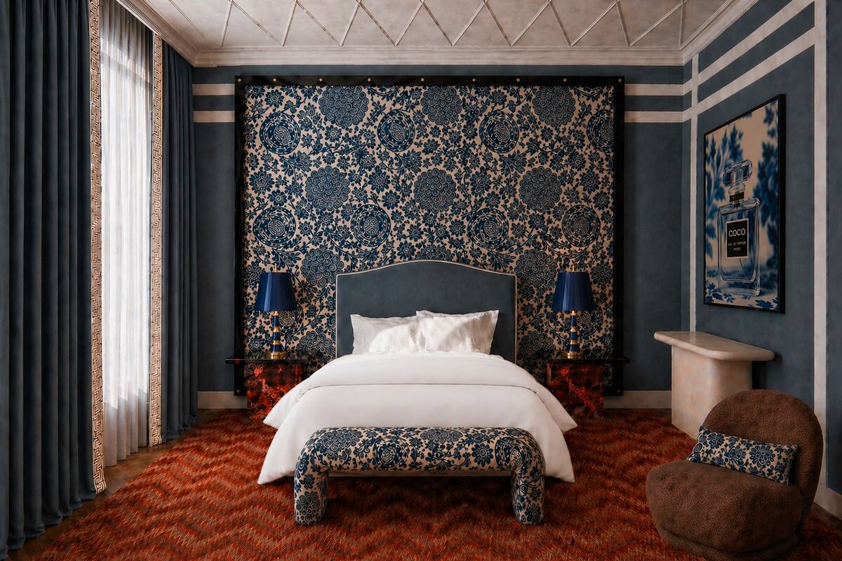 Une chambre à coucher avec une tête de lit à motifs, un lit avec une literie blanche, deux lampes de chevet, une table de chevet, un fauteuil rond et une œuvre d’art accrochée au mur.