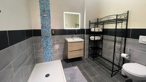 Une salle de bain moderne équipée d’une douche, d’un lavabo et de toilettes.