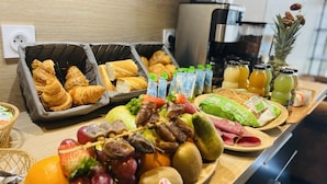 A breakfast buffet with croissants, fruits, and various beverages. - Leclerc hôtel (Le Mans)