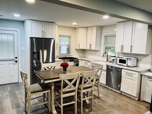 Enjoy cooking in this well-equipped kitchen with a central island, stainless steel appliances, and ample cabinetry.