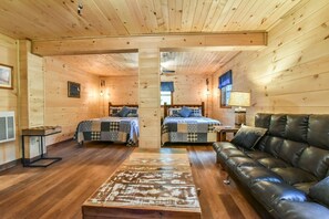 Relax in this cabin-style room with two double beds, a leather sofa, and a wooden coffee table.